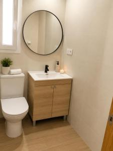 a bathroom with a white toilet and a mirror at COSTA DE ALMERIA PLAYA in Almería +11 photos