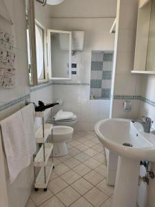a white bathroom with a sink and a toilet at Casa vacanze Piedigrotta in Pizzo +26 photos
