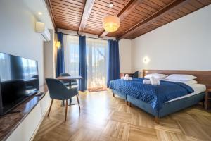 a bedroom with a bed and a flat screen tv at Pensjonat Mikołajki in Mikołajki