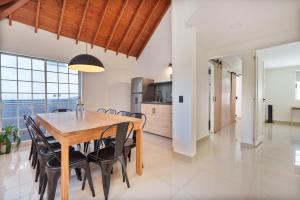 a kitchen and dining room with a wooden table and chairs at Hotel Santa Ana Medellin in Medellín