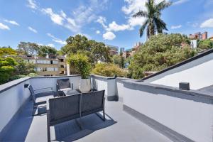 a balcony with two chairs and a table on a roof at Hotel Santa Ana Medellin in Medellín