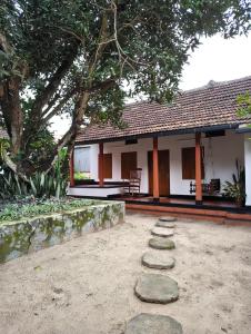 a house with a table and a chair in front of it at Chettiparambil Heritage in Cochin
