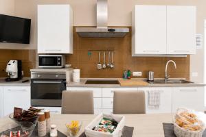a kitchen with white cabinets and a table with chairs at Merus in Faicchio +13 photos