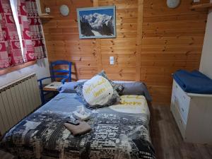 a bedroom with a bed in a wooden room at Auberge La Coulette in Vars