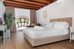 a bedroom with a large white bed and a window at Aurelia Boutique - Suites in Rhodes Town