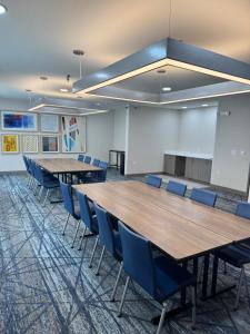 a conference room with wooden tables and blue chairs at Holiday Inn Express Deforest Madison Area by IHG in De Forest +89 photos