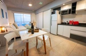 a kitchen and living room with a table and chairs at Cómodo departamento centro de Salta by BEDBOOK in Salta
