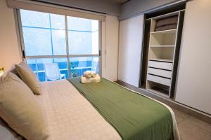 a bedroom with a bed and a large window at Cómodo departamento centro de Salta by BEDBOOK in Salta
