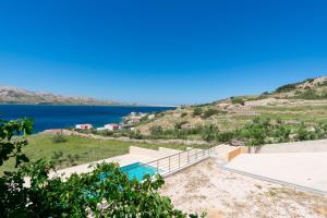 a house on the hill with a view of the water at Apartments PoolHouse in Metajna