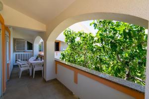 an outdoor balcony with a green plant at Apartments PoolHouse in Metajna