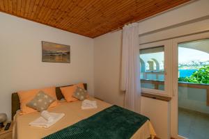 a bedroom with a bed and a window at Apartments PoolHouse in Metajna +87 photos