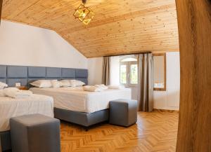 a bedroom with two beds and a wooden ceiling at Villa Osmani in Shkodër