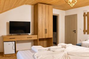 a room with two beds and a television on a cabinet at Villa Osmani in Shkodër
