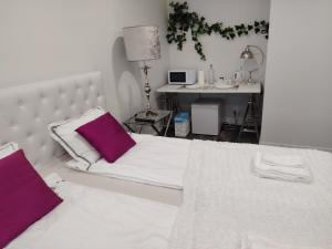 a bedroom with a bed with purple pillows and a desk at Anne House in Raisio +5 photos