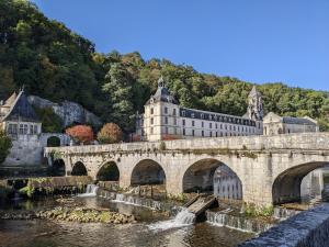 a bridge over a river in front of a building at LoFt Les Castilléres in Condat-sur-Trincou