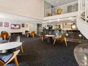 eine Lobby mit Tischen und Stühlen und einer Bar in der Unterkunft ibis Styles Canberra in Canberra