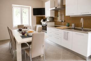 a kitchen with white cabinets and a table and chairs at Merus in Faicchio