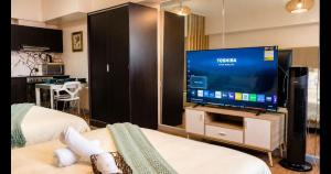 a room with two beds and a large screen television at Tripleview luxurious eton baypark manila in Manila