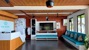 a living room with a tv and a couch at The Pearl Seaview in Fulidhoo