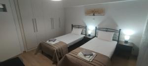 two beds in a small room with lights on at Little Citrus Yard in Karlovasi