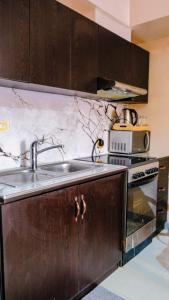 a kitchen with a sink and a stove at Tripleview luxurious eton baypark manila in Manila