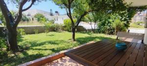 a wooden deck with a bench in a yard at Little Citrus Yard in Karlovasi