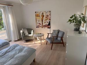 a bedroom with a bed and two chairs and a table at Brøndums B & B in Hjørring