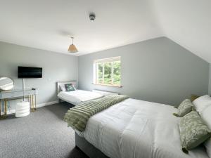 a bedroom with two beds and a desk and a window at Ivy Guesthouse in Kilkenny
