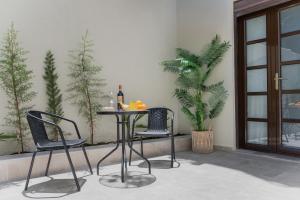 a table with two chairs and a bottle of wine at Aurelia Boutique - Suites in Rhodes Town