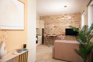 a living room with a couch and a brick wall at Kallia Castle apartments in Chios