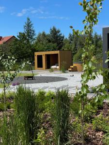 a garden with a house with a swing at Siedlisko na wydmach,domki klimatyzowane,starlink internet,parking in Łeba +199 photos
