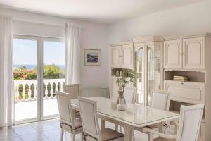 a white dining room with a table and chairs at Villa Polymnia in Kaligata