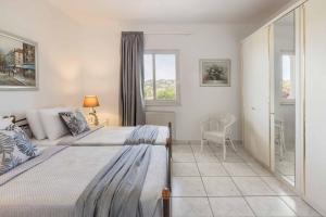 a bedroom with two beds and a window at Villa Polymnia in Kaligata +10 photos