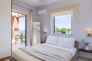 a bedroom with a large bed with a window at Villa Agnandi in Lakíthra +17 photos