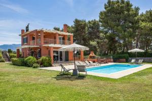 a villa with a swimming pool in front of a house at Villa Agnandi in Lakíthra