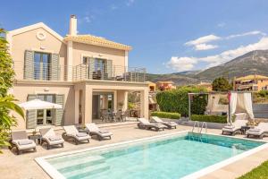 a villa with a swimming pool and a house at Casa Bella in Karavádhos