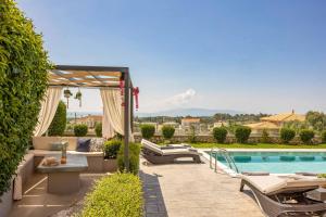 a backyard with a swimming pool and chairs and a swimming pool at Casa Bella in Karavádhos