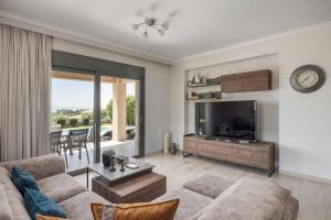 a living room with a couch and a flat screen tv at Casa Bella in Karavádhos