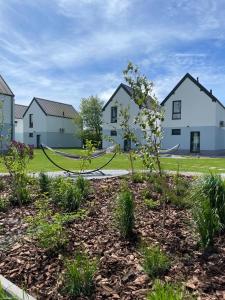 a row of houses with a hammock in a garden at Siedlisko na wydmach,domki klimatyzowane,starlink internet,parking in Łeba