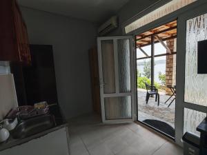a kitchen with a door open to a patio at Lana Seafront Apartments in Šušanj