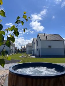 a building with a pool in front of a yard at Siedlisko na wydmach,domki klimatyzowane,starlink internet,parking in Łeba