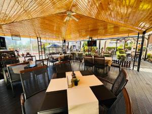 a restaurant with tables and chairs and a ceiling at Ivian Family Hotel in Ravda