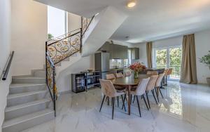 a dining room with a table and chairs and a staircase at Lotus Villas Resort in Pula