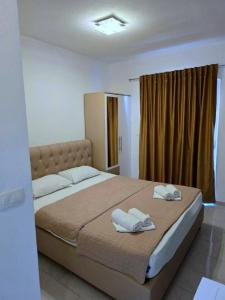 a bedroom with a large bed with two towels on it at Vila Cattleya in Donji Štoj