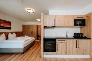 a bedroom with a bed and a kitchen with a sink at KitzSki Living in Kitzbühel