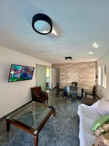 a living room with a glass table and a couch at Casa Cris cabo frio in Cabo Frio