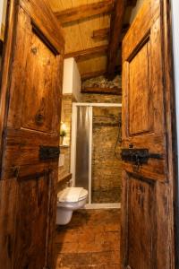 a bathroom with a toilet and a wooden door at Antica Calvasino in Lezzeno
