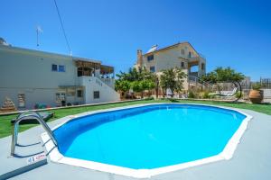 a large swimming pool in front of a house at Fisi & Wellness Exclusive Villa with Spa Vibes in Stavromenos