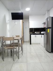 a kitchen with a table and chairs and a refrigerator at MiniSuite in Machala
