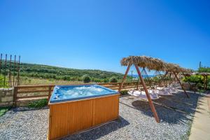 a hot tub with an umbrella and a swing at Fisi & Wellness Exclusive Villa with Spa Vibes in Stavromenos +201 photos